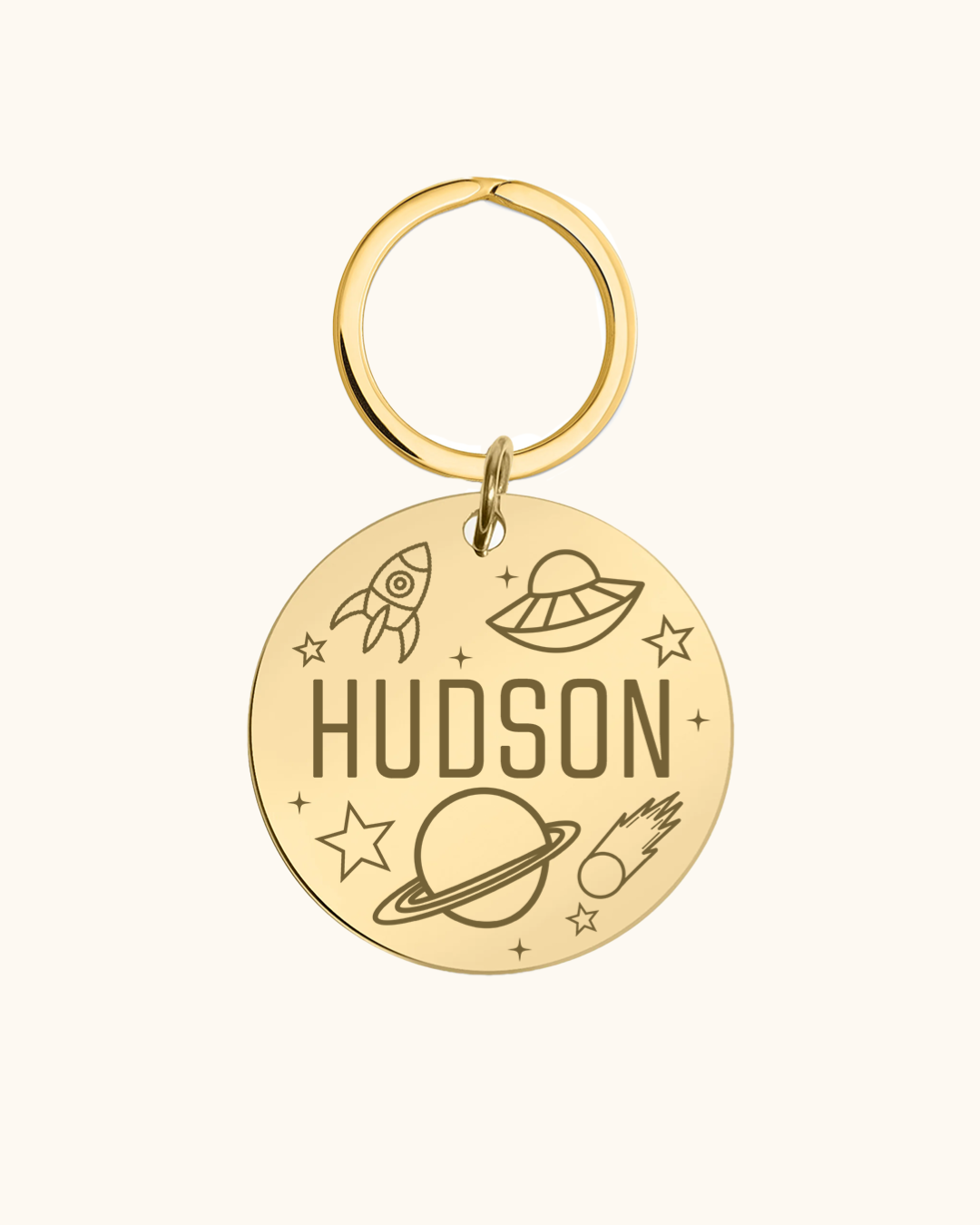 Gold pet tag with 'Hudson' and space-themed designs on a white background