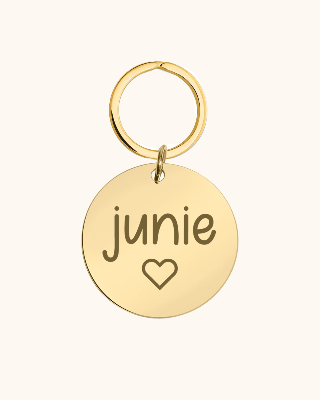 Gold pet tag with 'junie' and a heart on a white background