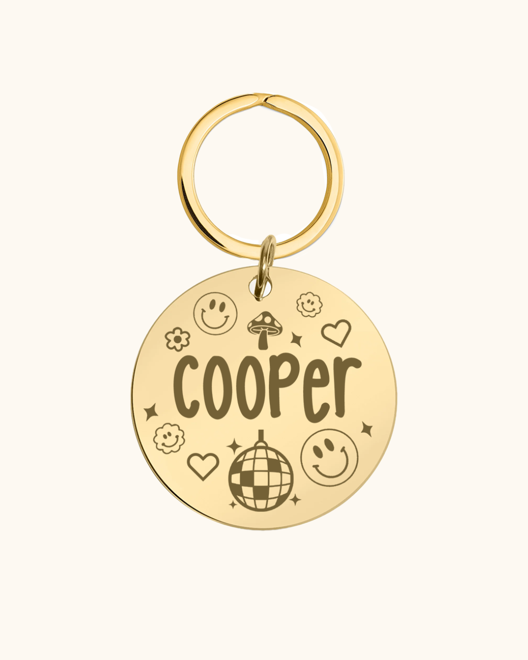 Gold pet tag with 'Cooper' engraved on a white background