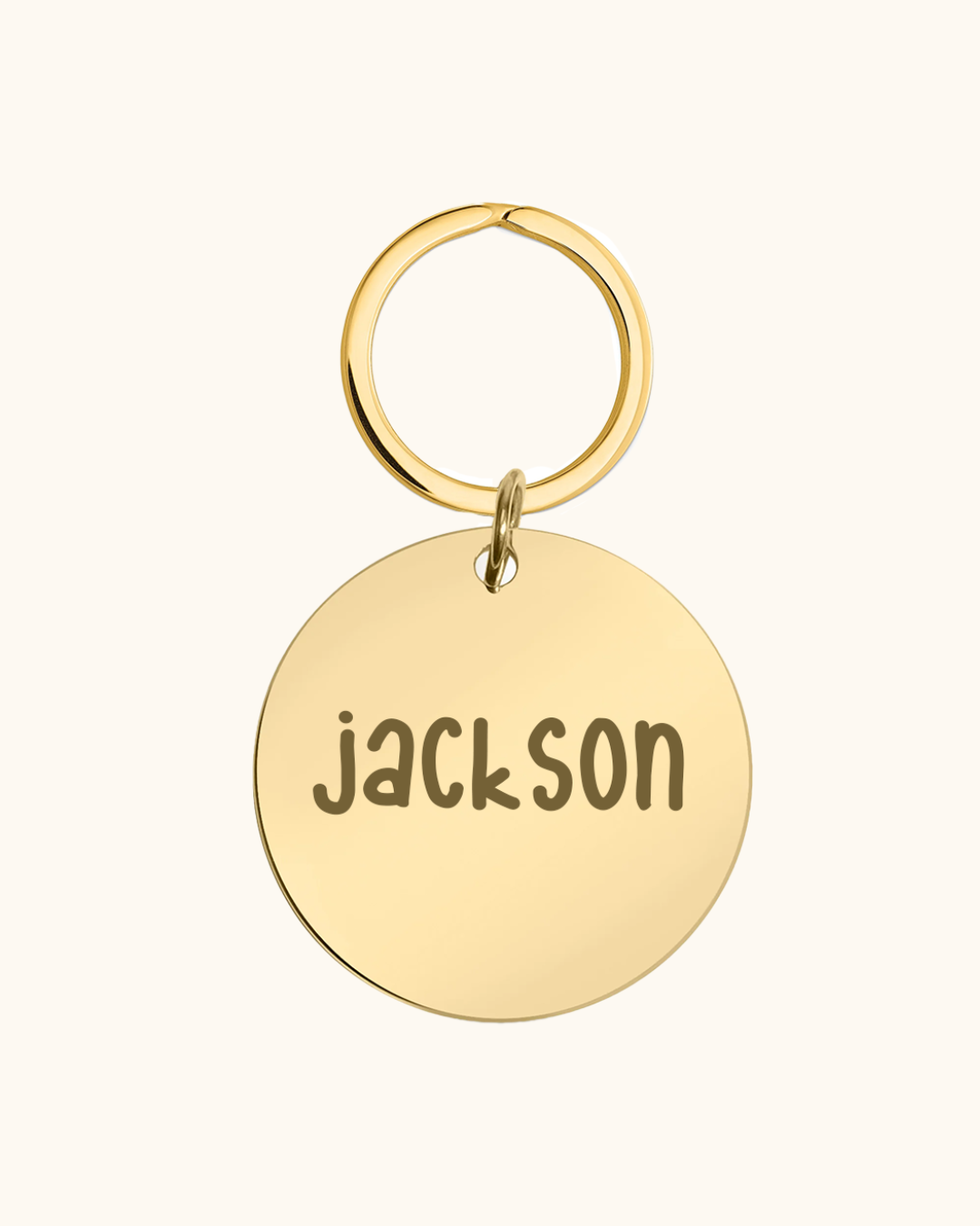 Gold dog tag with 'Jackson' engraved on a white background