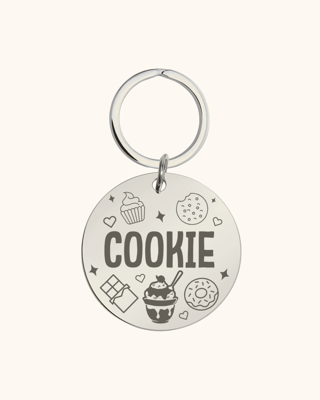 Silver pet tag with 'COOKIE' text and various icons on a white background
