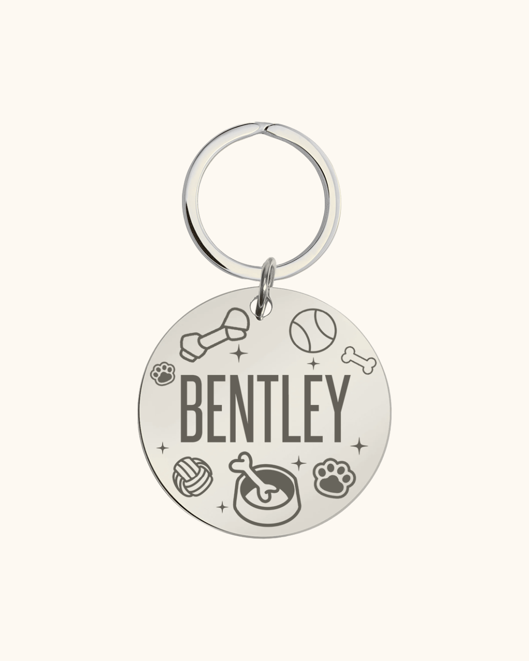 Silver pet tag with 'Bentley' engraved, featuring various dog-related icons on a white background.