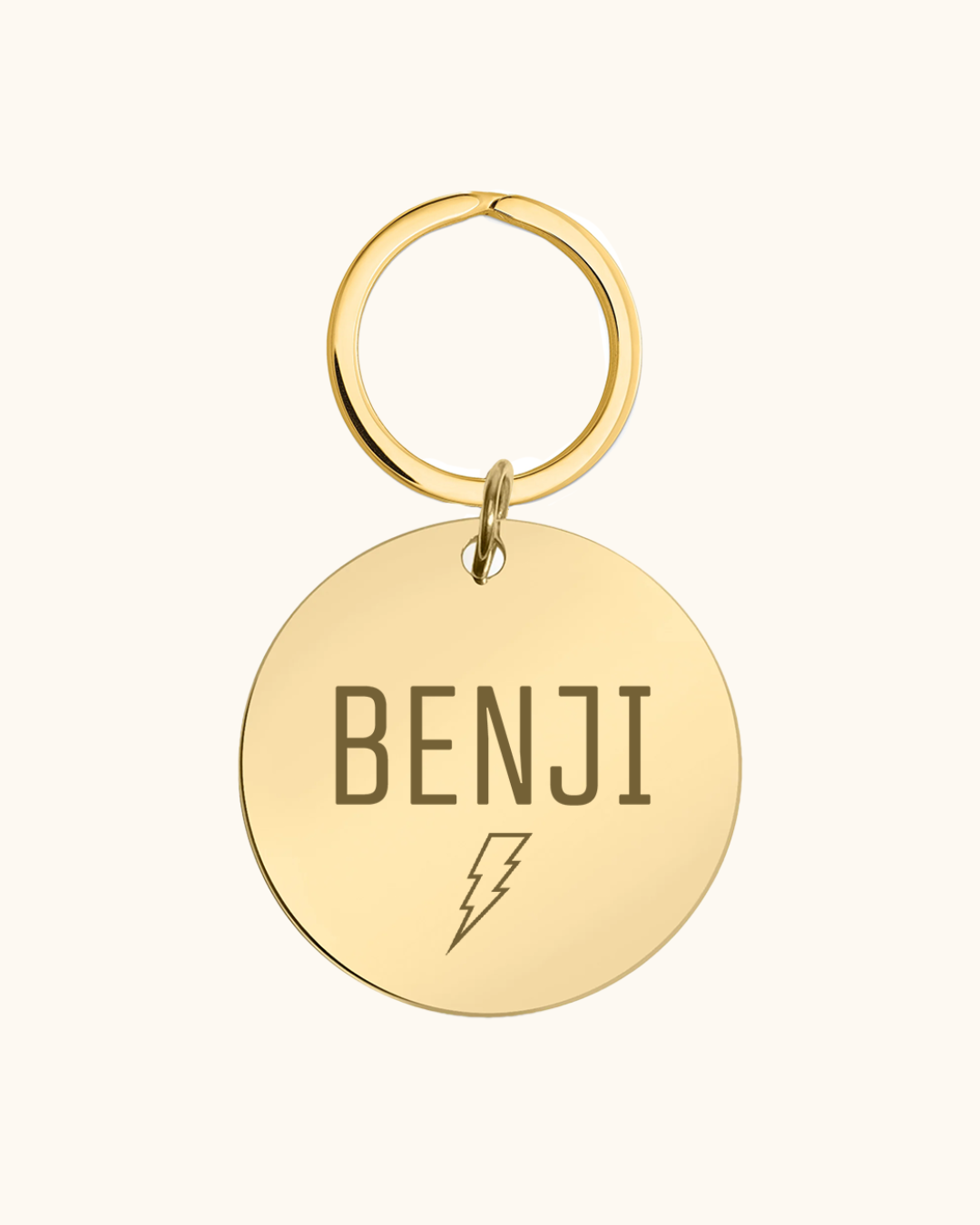 Gold pet tag with 'BENJI' and a lightning bolt on a white background