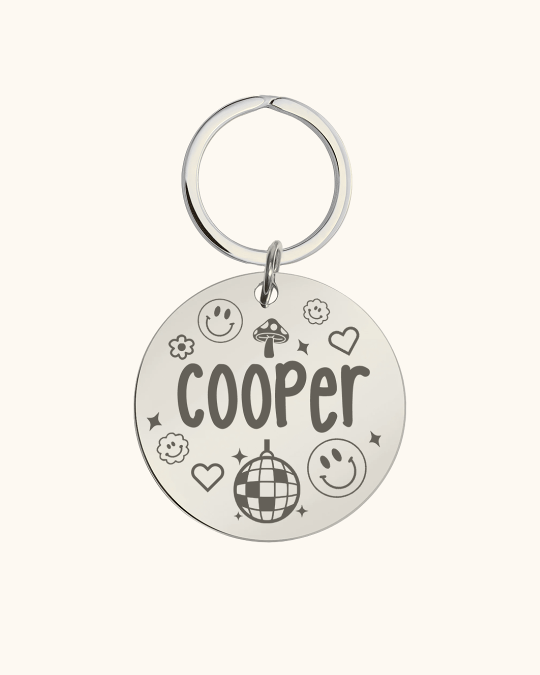 Pet tag silver with 'Cooper' engraved on a white background