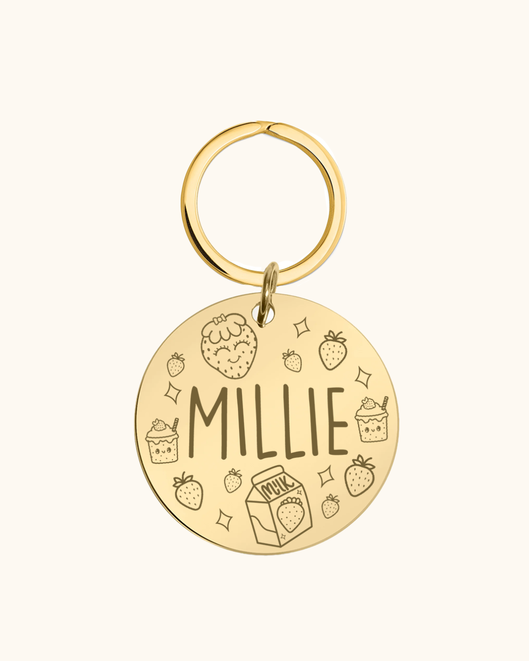 Gold pet tag with 'MILLIE' engraved on a white background